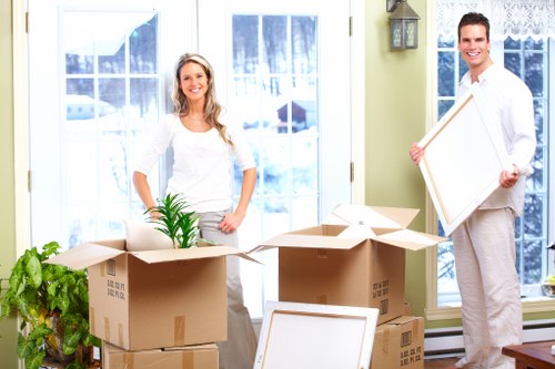 Removal team carrying furniture through a flat hallway